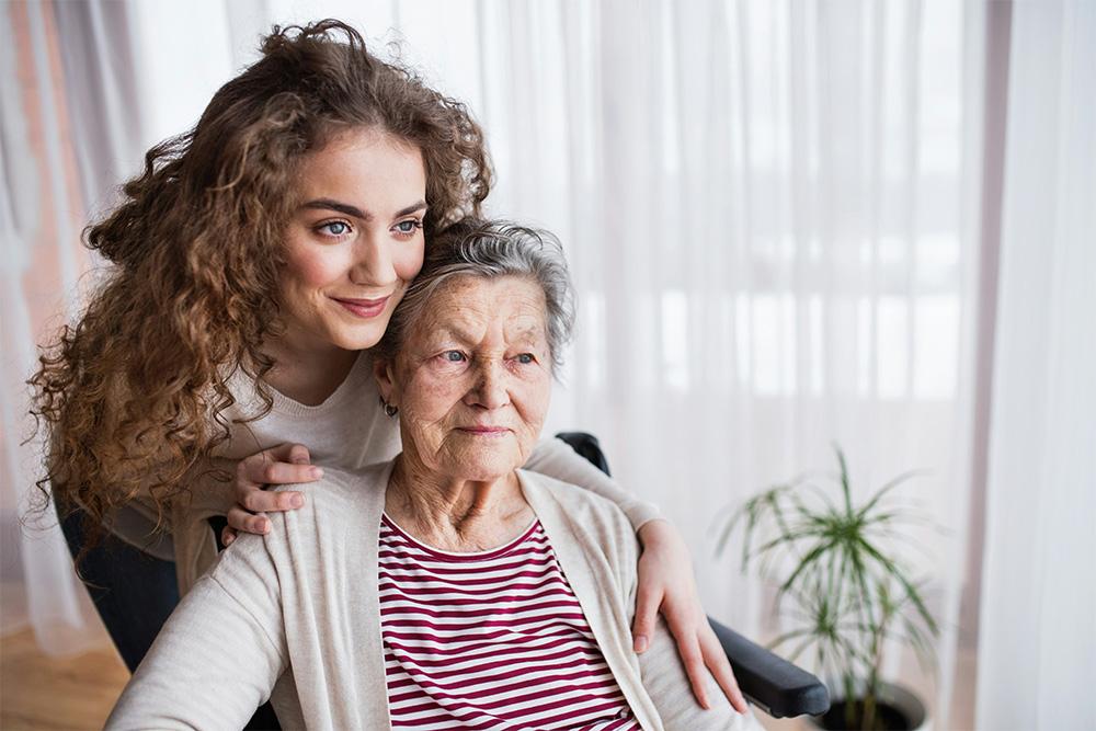 Older woman sitting with younger woman behind her